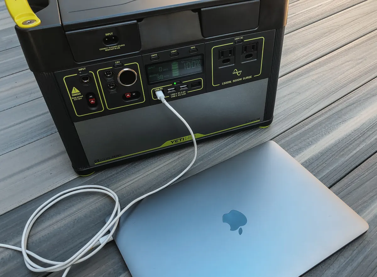 Estación de energía portátil con un ordenador portátil conectado por cable a una de sus salidas